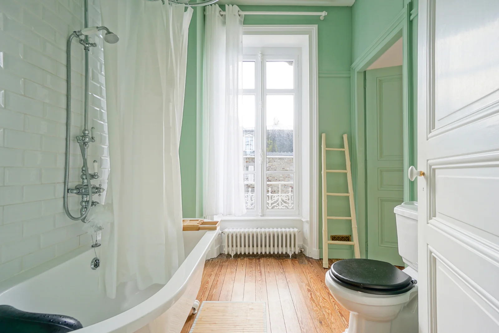 Salle de bain verte du Manoir Ducey avec baignoire et douche