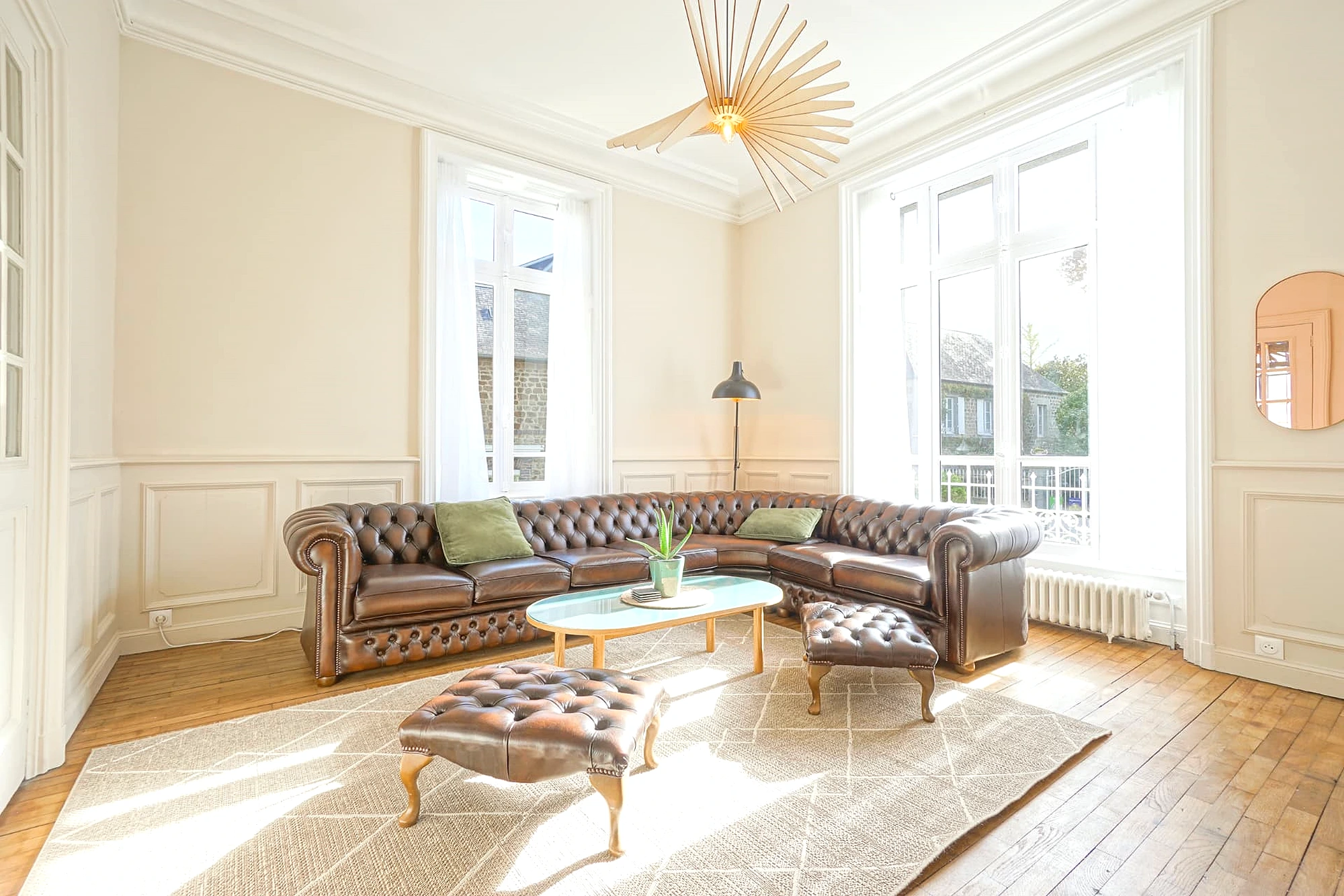 Salon lumineux du Manoir Ducey avec canapé Chesterfield en cuir