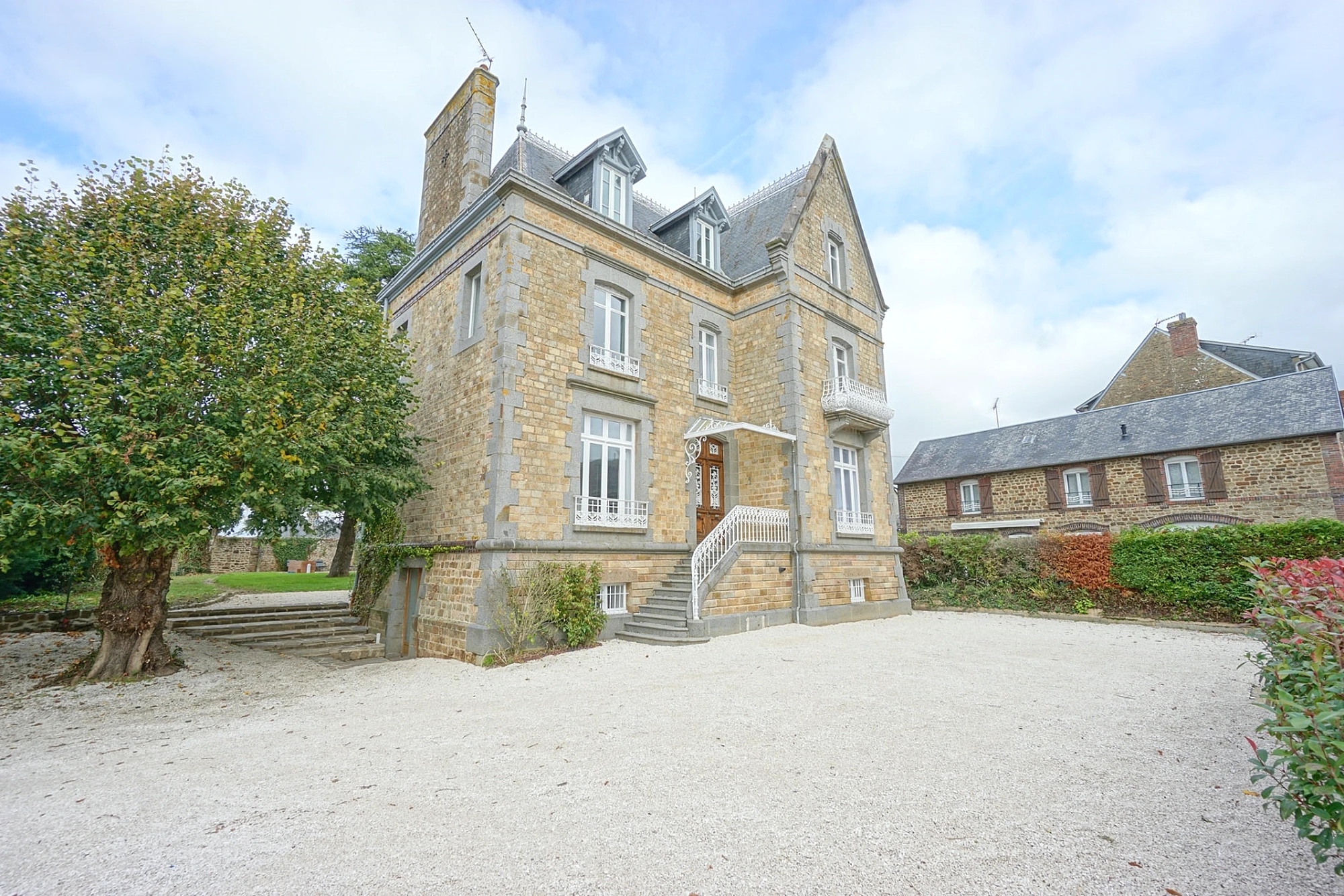 Façade en pierre et cour d'honneur du Manoir Ducey en Normandie