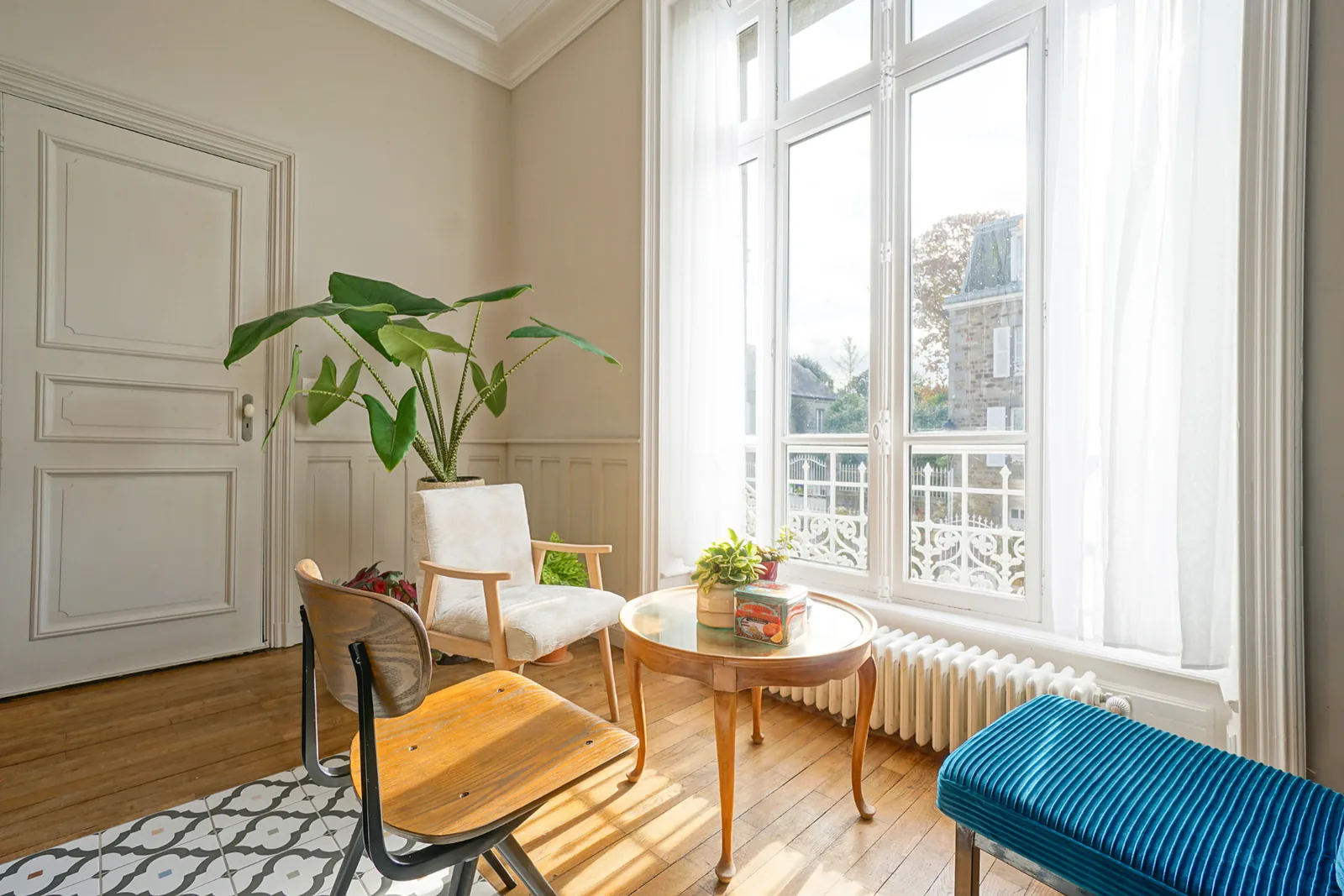Coin salon près d'une haute fenêtre du Manoir Ducey, lumière du matin sur le parquet